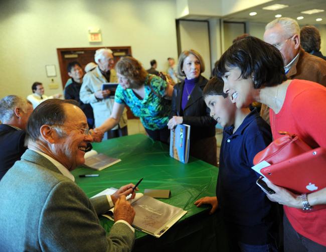 Former Gov. Thomas H. Kean talks with Etan Zeller MacLean, 11, and Susana MacLean of Westfield after signing their copy of 'The Nature of the Meadowlands.' 